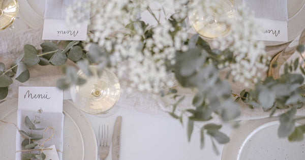 Hochzeitstisch mit Teller, Weingläsern, Blumen und Servietten von oben