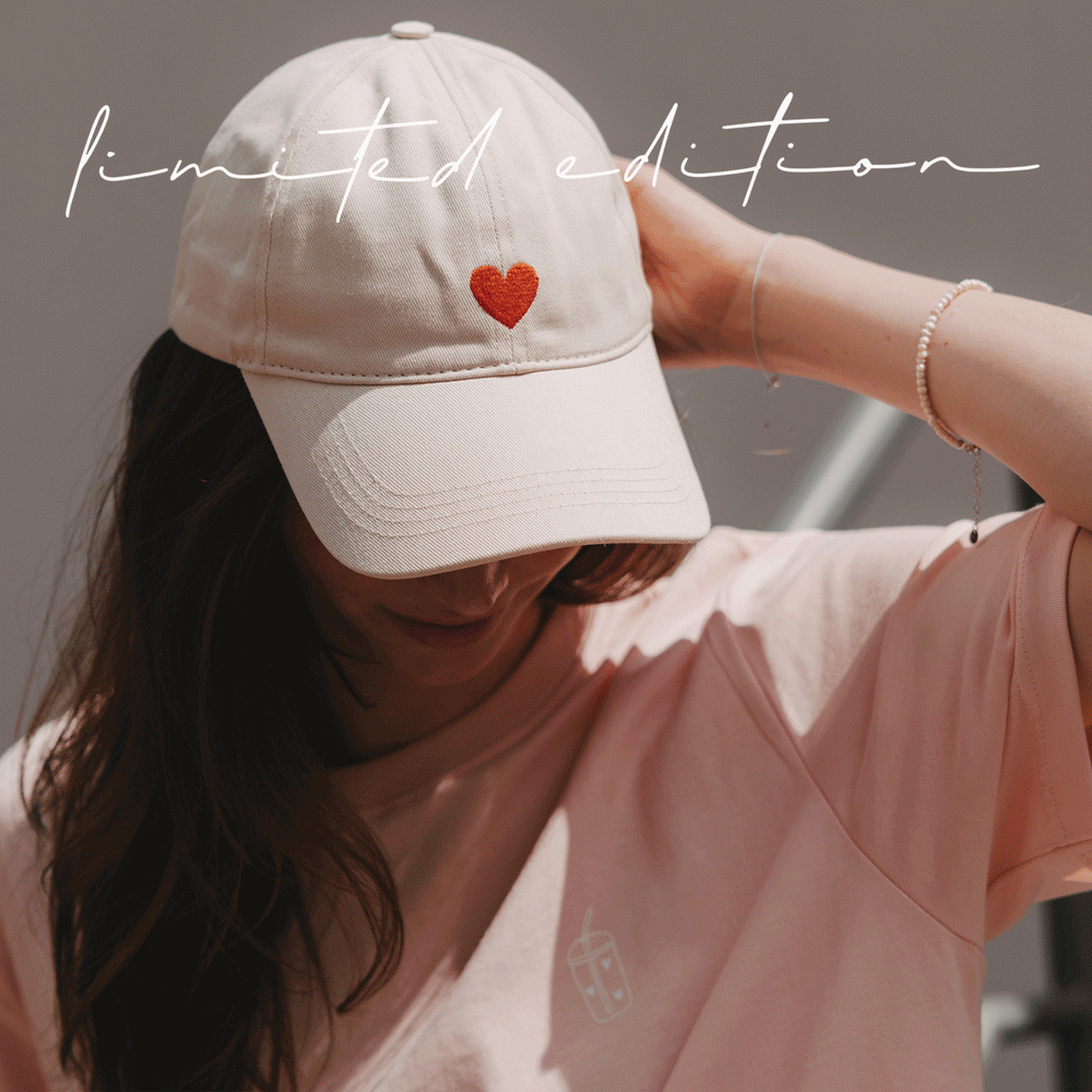 Animierte Bildfolge der beigen Cap mit roter Herz- und „Oh Happy Day“-Stickerei in sommerlichen Lifestyle-Szenen
