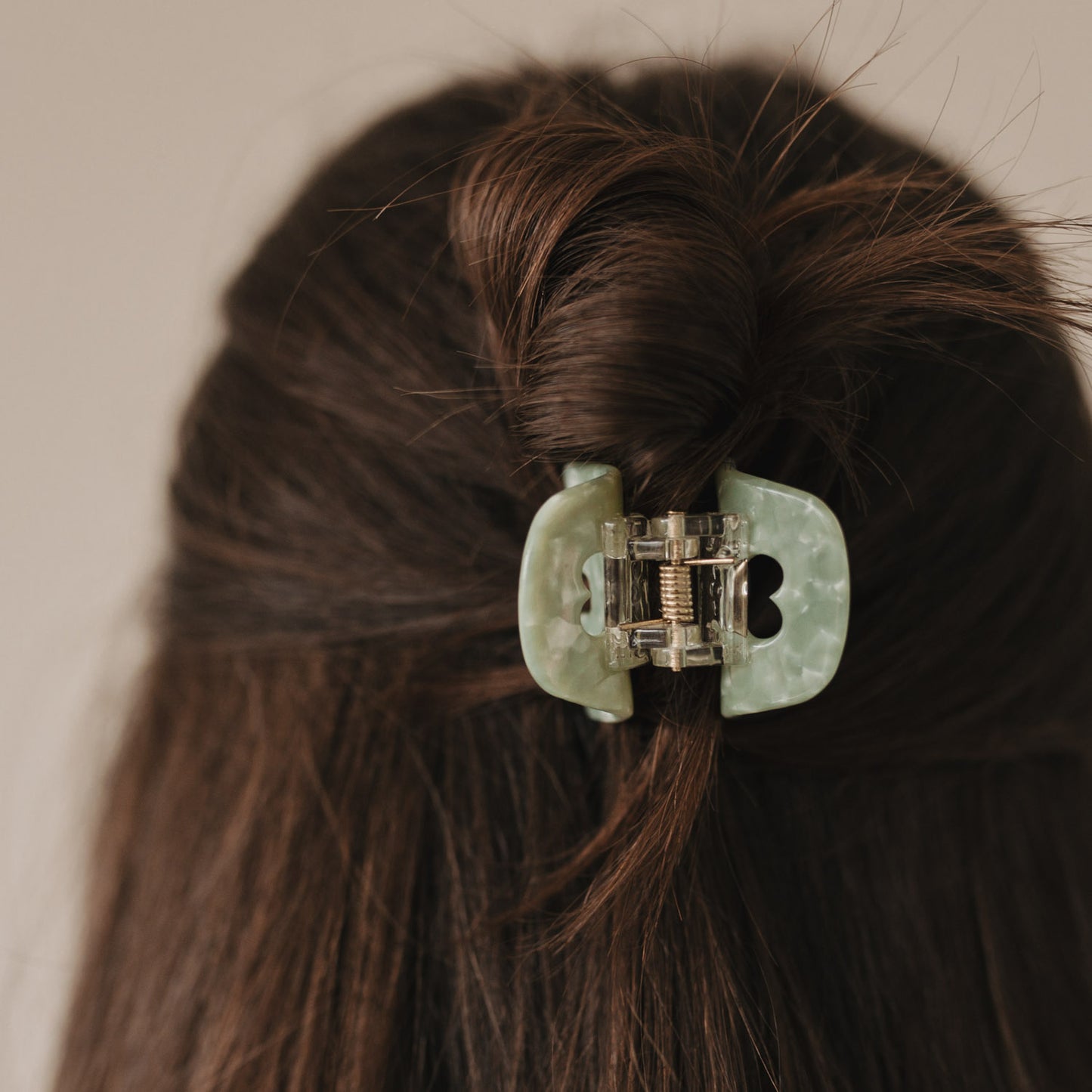 Rückansicht einer Frisur mit Haarspange klein Herz jade im Knoten – zartes Design mit ausgestanztem Herz.