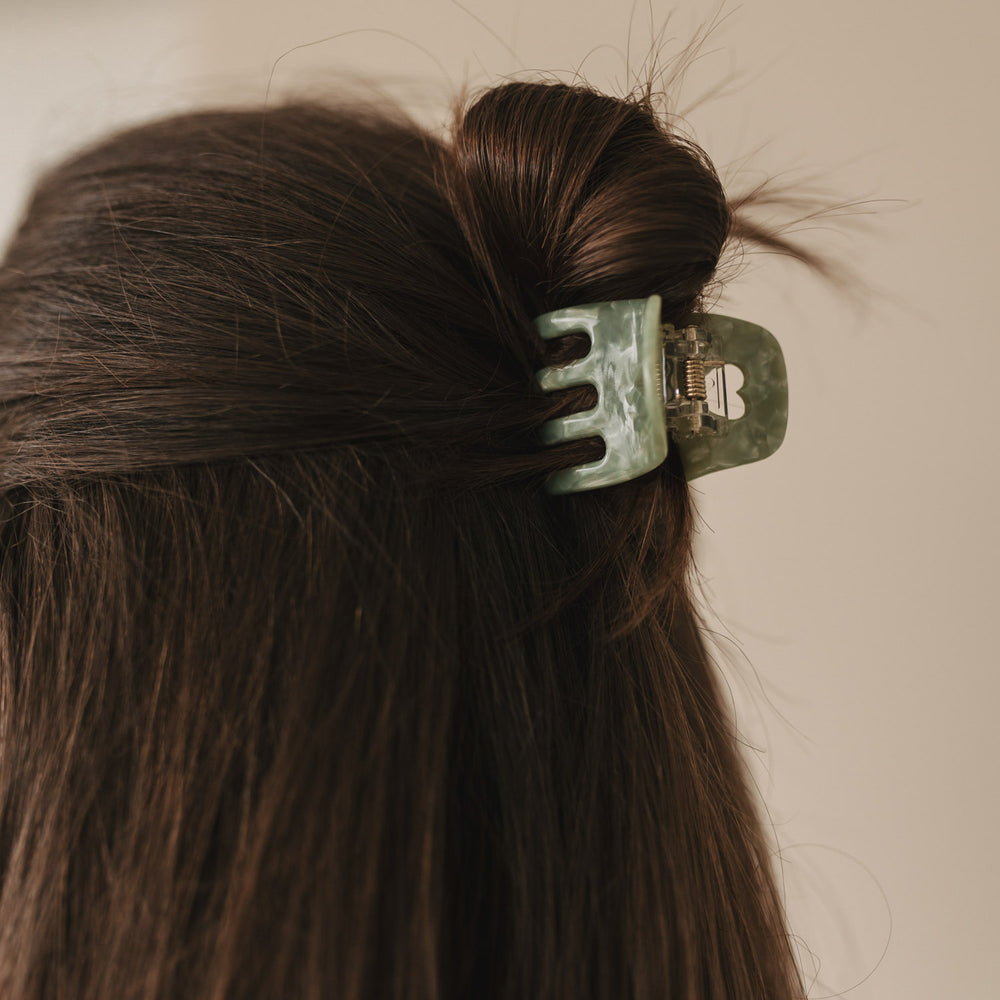 Seitenansicht einer dunkelhaarigen Frau mit Hochsteckfrisur, gehalten von der Haarspange klein Herz jade.