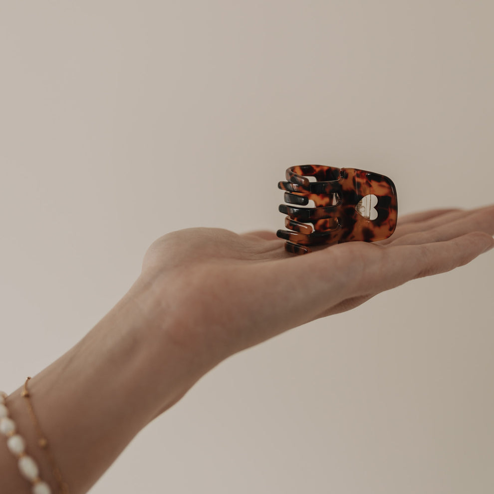 Kleine Haarspange Herz Amber liegt in geöffneter Handfläche