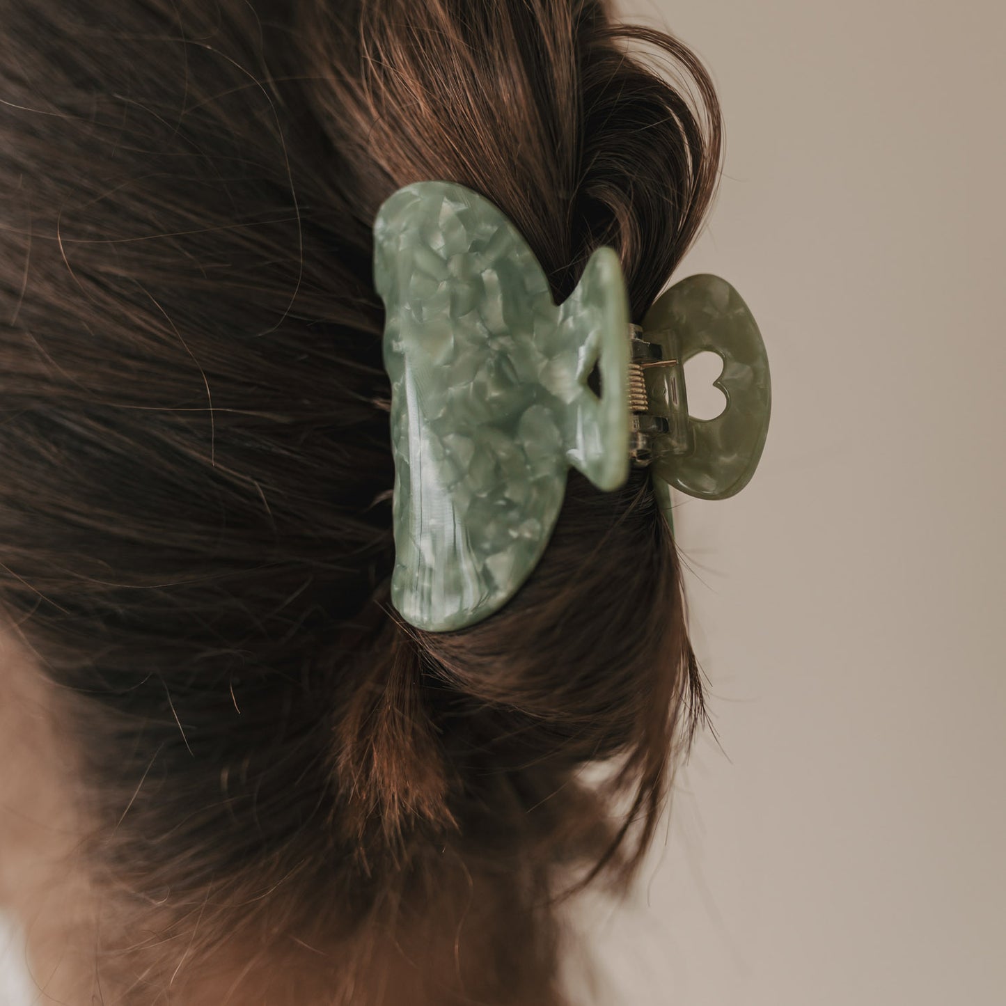 Nahaufnahme der großen Haarspange Herz jade mit Marmorierung und ausgestanztem Herz im Haar