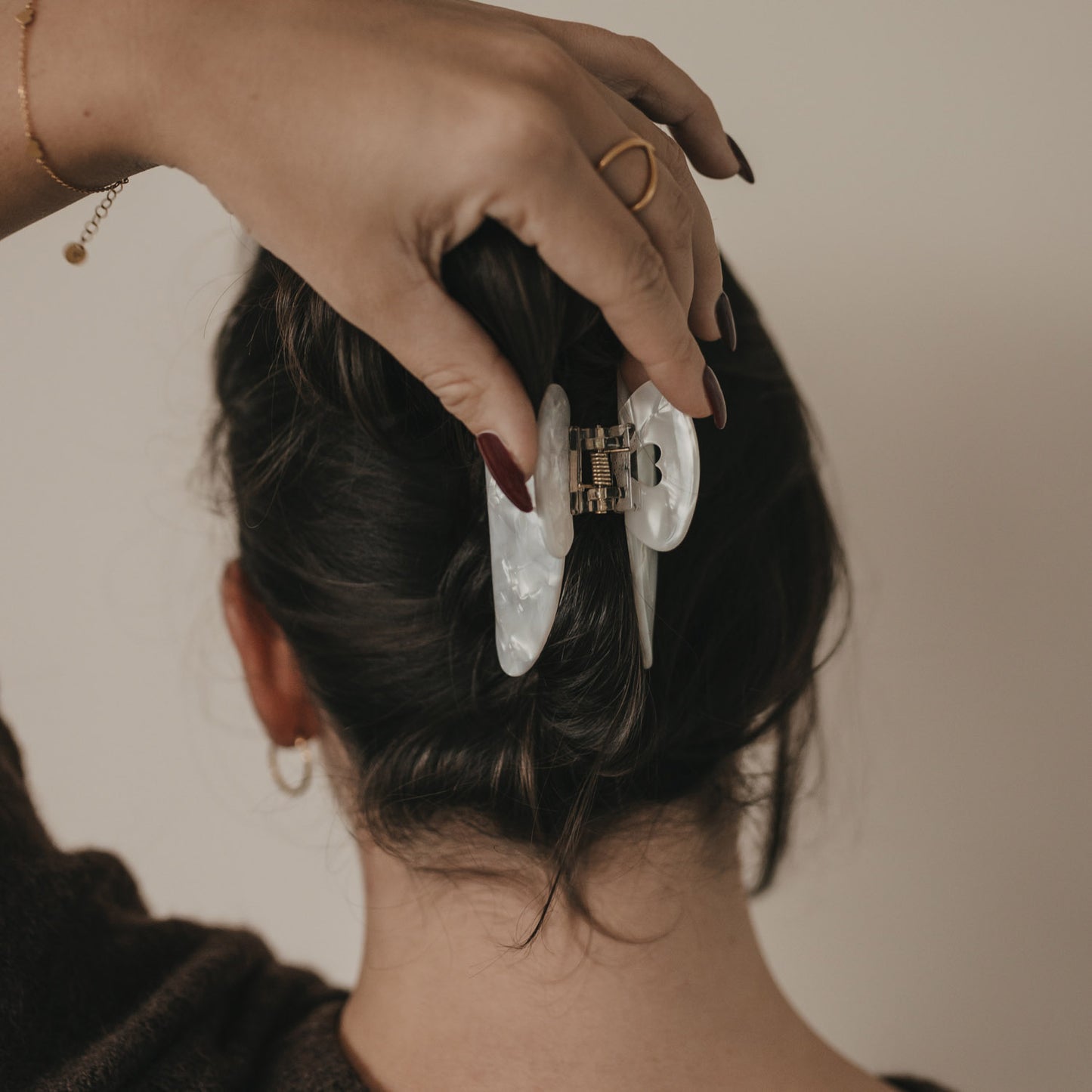 Frau steckt Haarspange Maxi Herz Pearl in ihr Haar, Nahaufnahme.