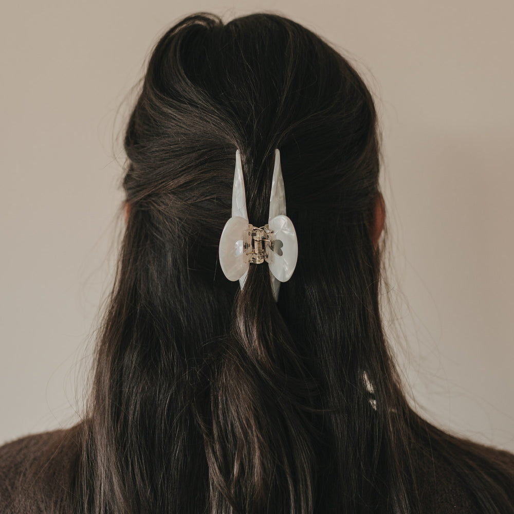 Maxi Herz Pearl Haarspange hält eine Half-Up-Frisur im dunklen Haar.