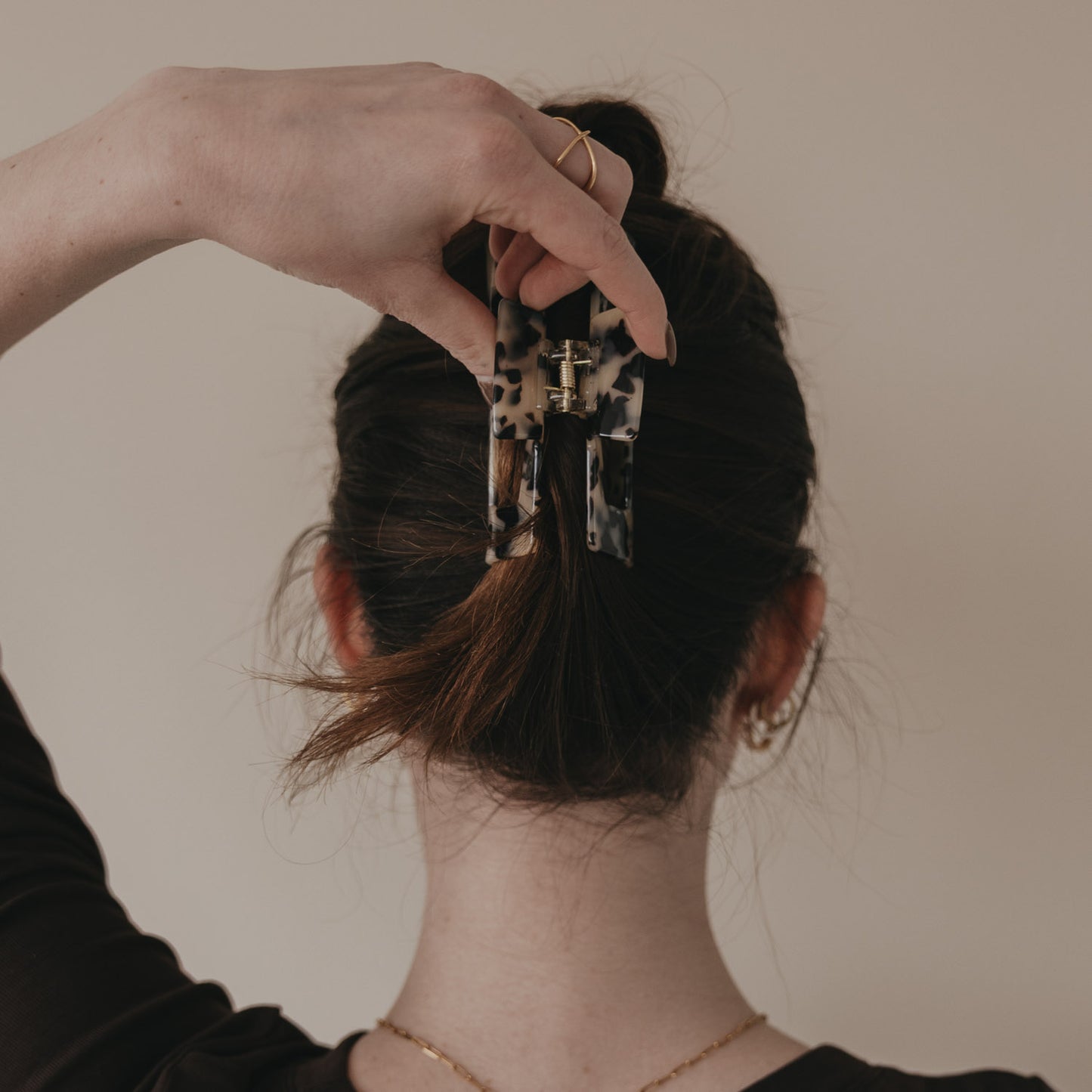 Hand befestigt große Haarspange im Leo-Design im Dutt