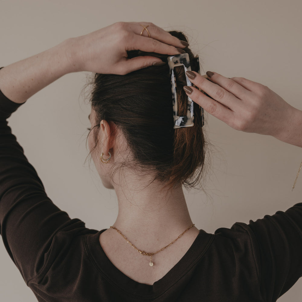 Große eckige Haarspange in Leo-Optik wird im hochgesteckten Haar platziert