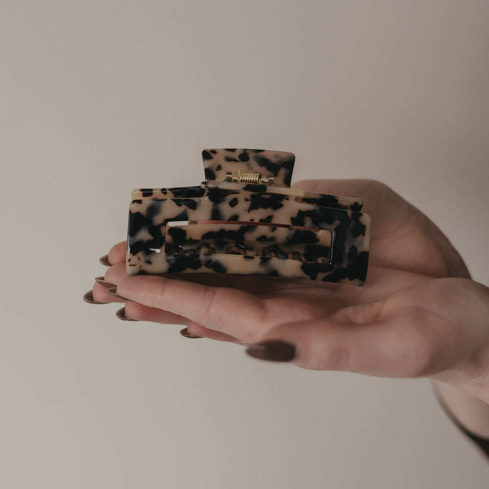 Große eckige Haarspange in Leo-Optik in der Hand präsentiert