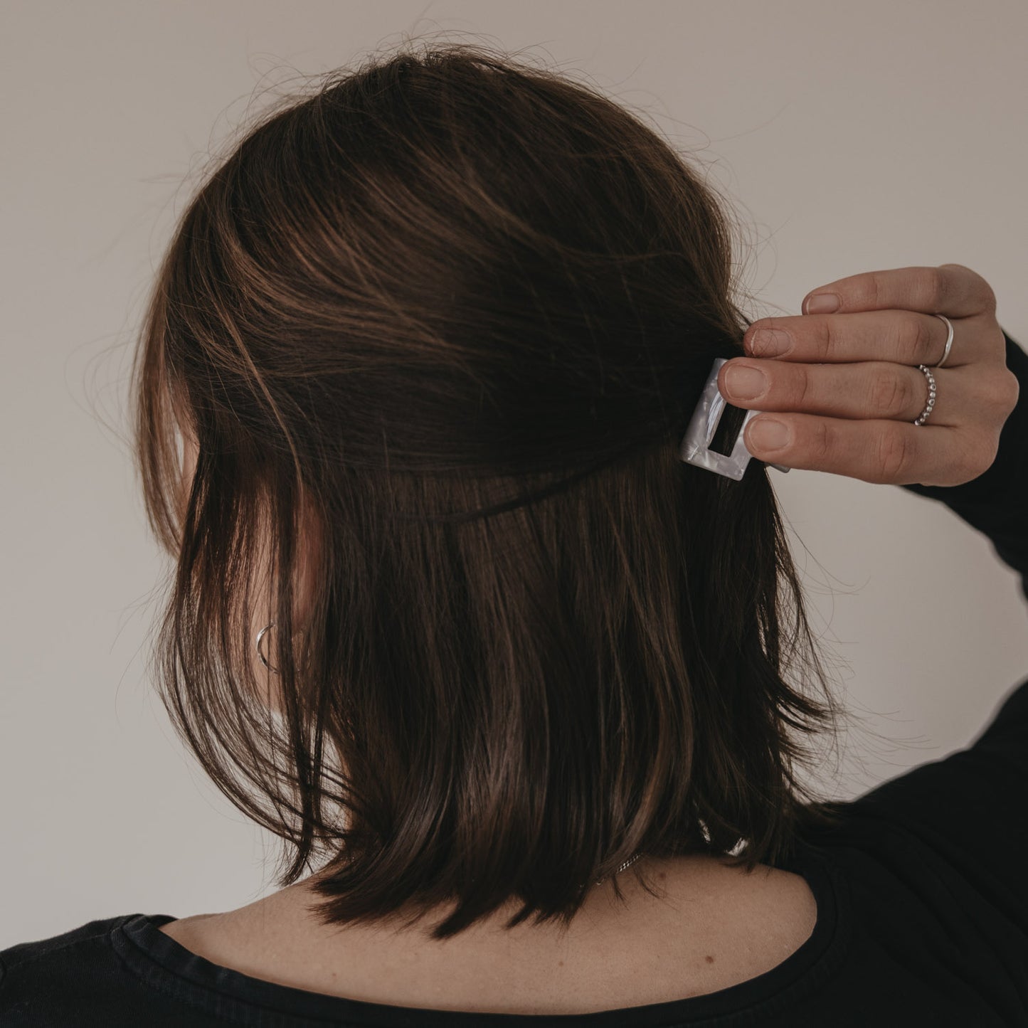 Hand befestigt kleine Haarspange eckig in Perlmutt-Optik im halboffenen Haar