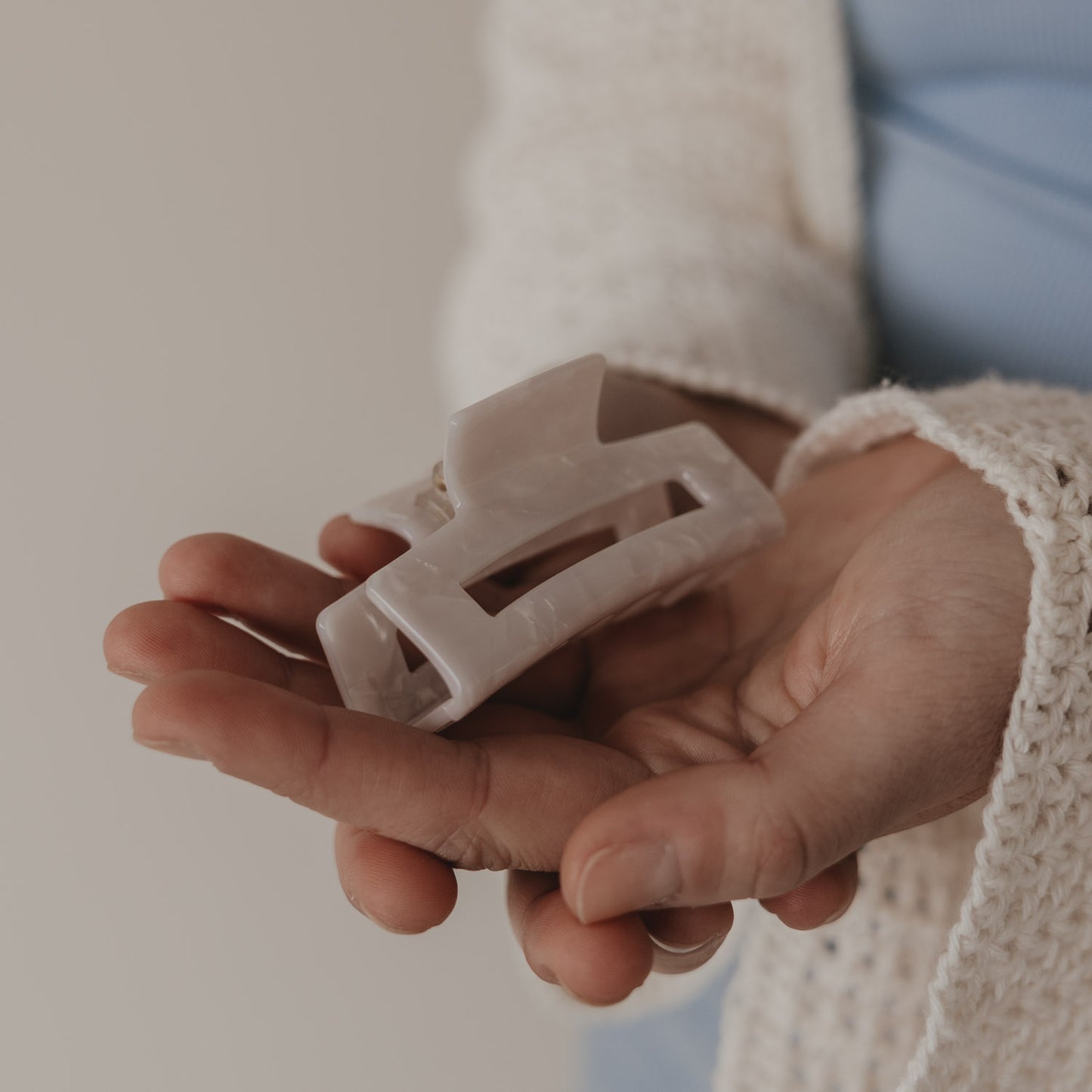 Große Haarspange eckig in Perlmutt-Optik in der Hand präsentiert
