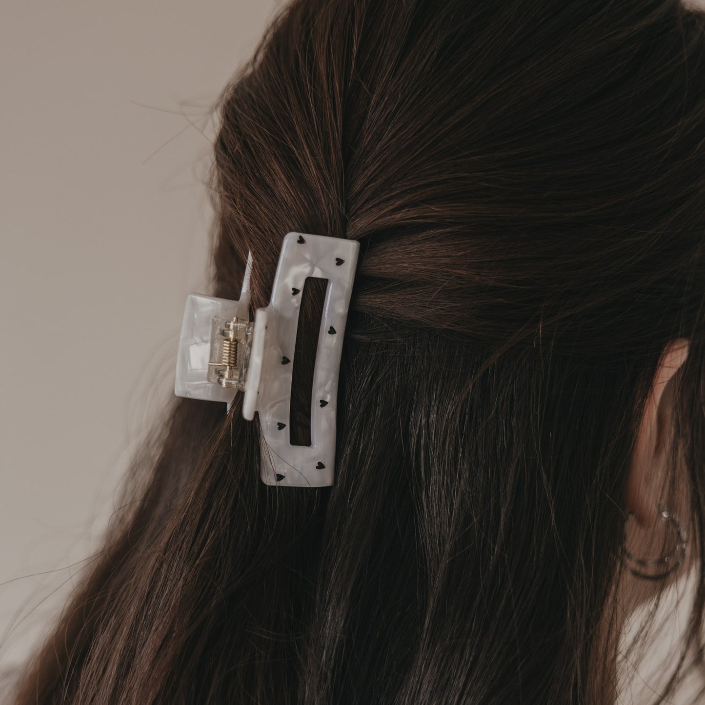 Detail der großen Haarspange eckig in Perlmutt-Optik mit schwarzen Herzen im Haar