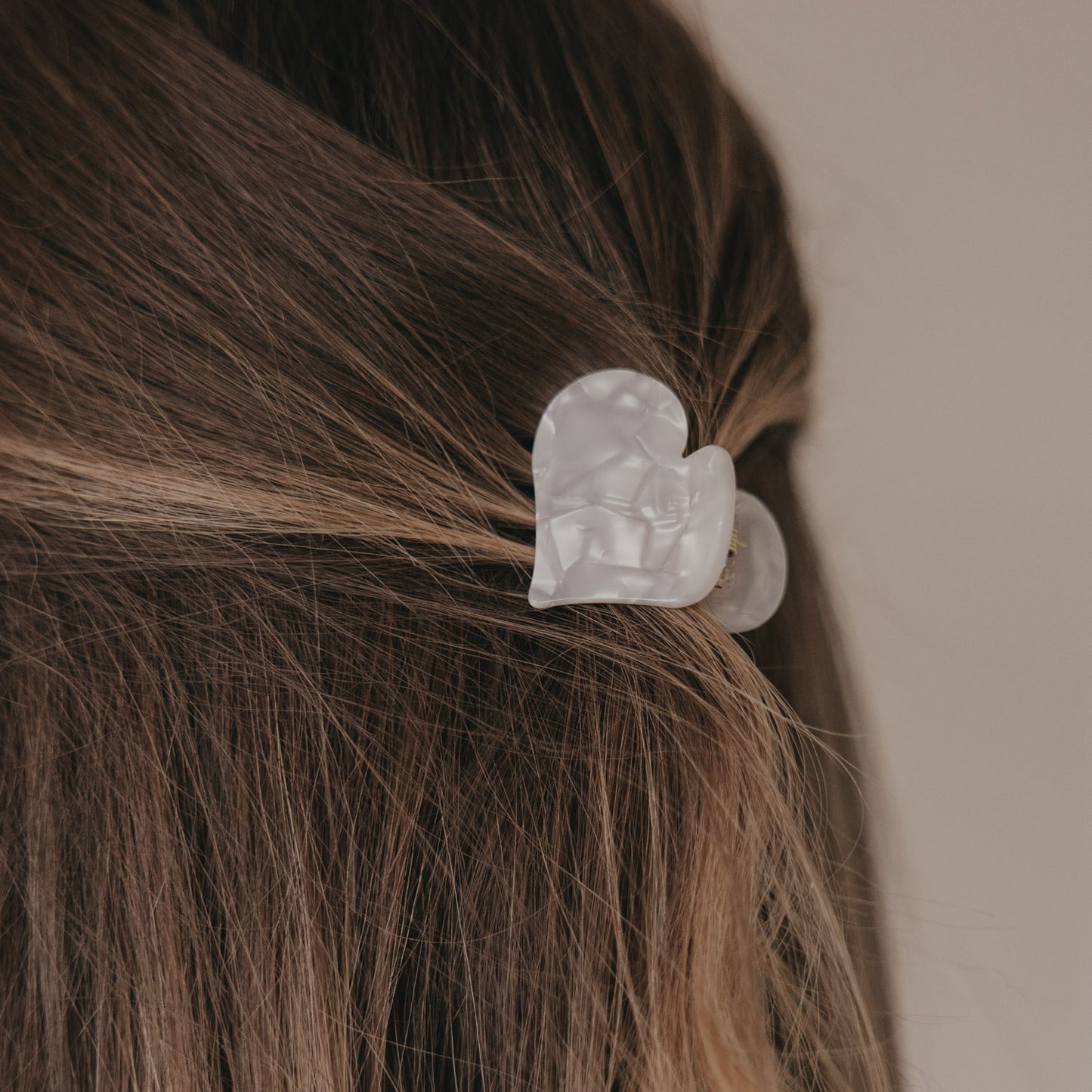 Große Haarspange in Herzform Pearl im halboffenen braunen Haar