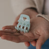 Kleine Haarspange Mint mit Herzdetail liegt in der Hand