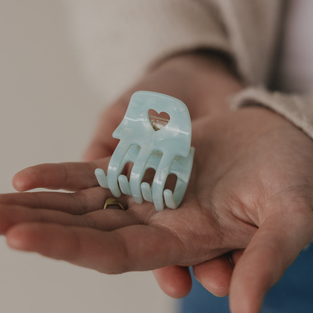 Kleine Haarspange Mint mit Herzdetail liegt in der Hand