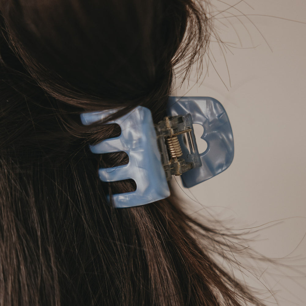 Detailaufnahme kleine blaue Haarspange mit Herzöffnung im Haar