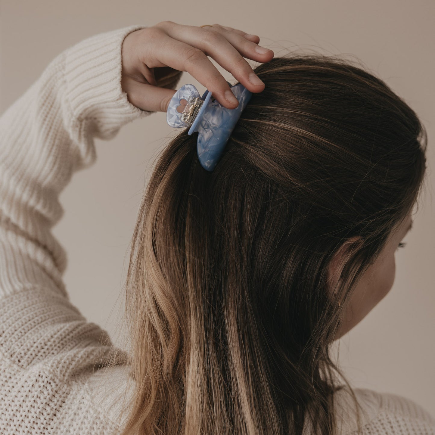 Große blaue Haarspange mit Herzdetail wird im Haar platziert