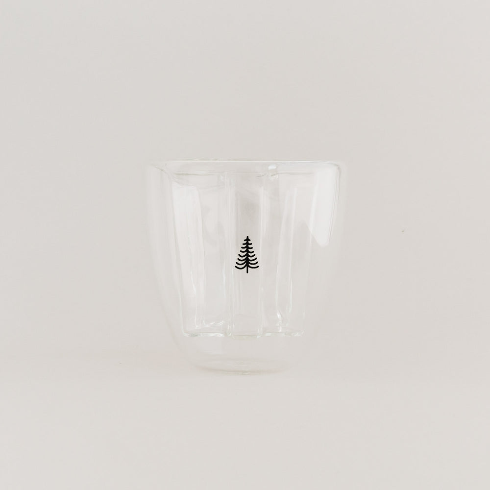 Doppelwandiges Tannenglas mit schwarzem Baum-Design, leer auf weißem Hintergrund.