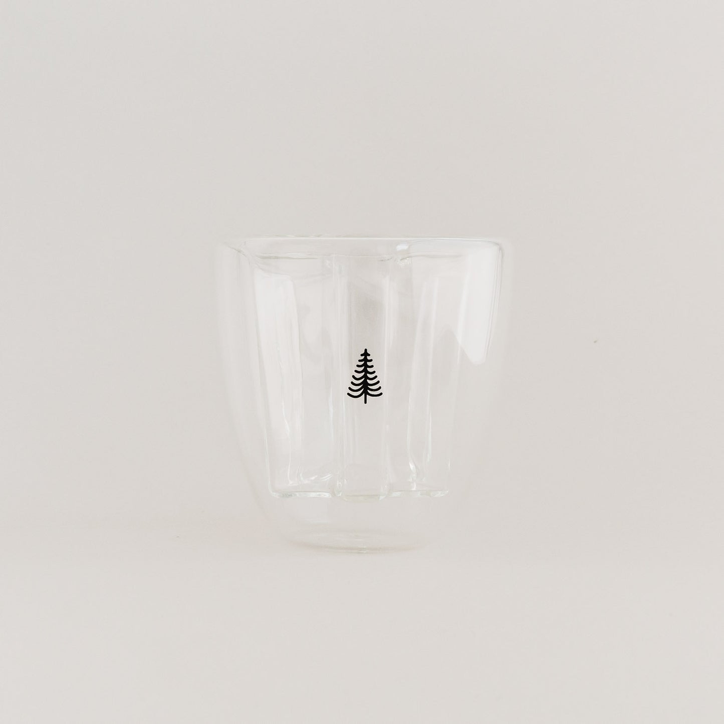 Doppelwandiges Tannenglas mit schwarzem Baum-Design, leer auf weißem Hintergrund.