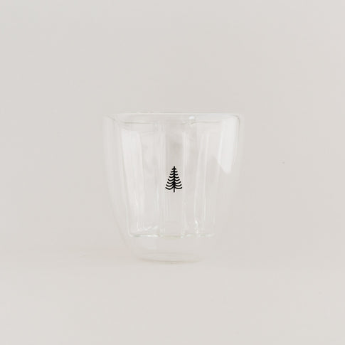 Doppelwandiges Tannenglas mit schwarzem Baum-Design, leer auf weißem Hintergrund.