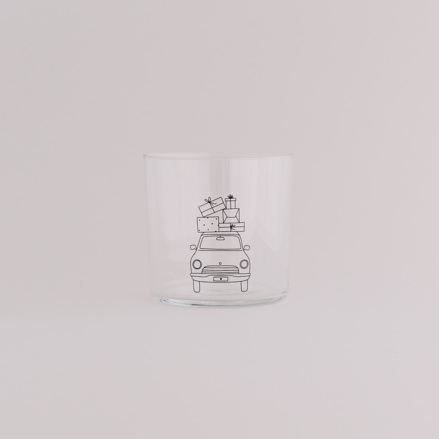 Klarglas mit Weihnachtsauto-Design und Geschenken auf dem Dach – festliche Tischdekoration.