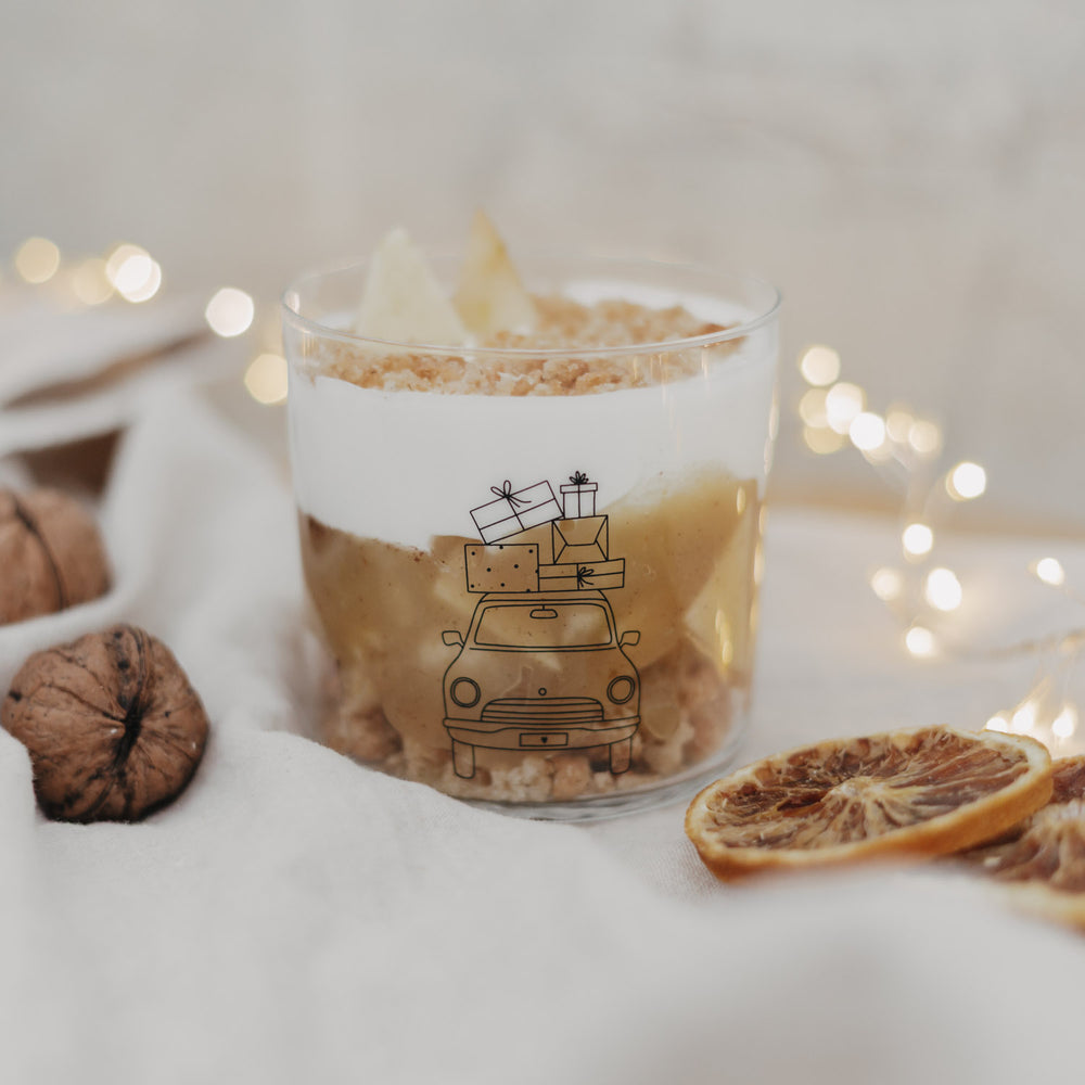 Weihnachtsdessert im Glas mit Auto-Motiv und Lichterkette im Hintergrund.