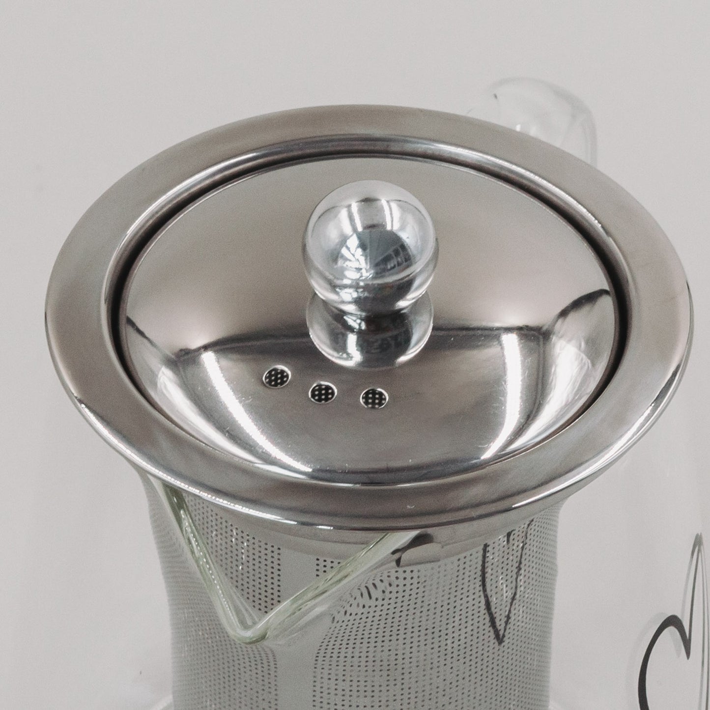 Nahaufnahme des Deckels und integrierten Teesieböffnungen der Teekanne Herz