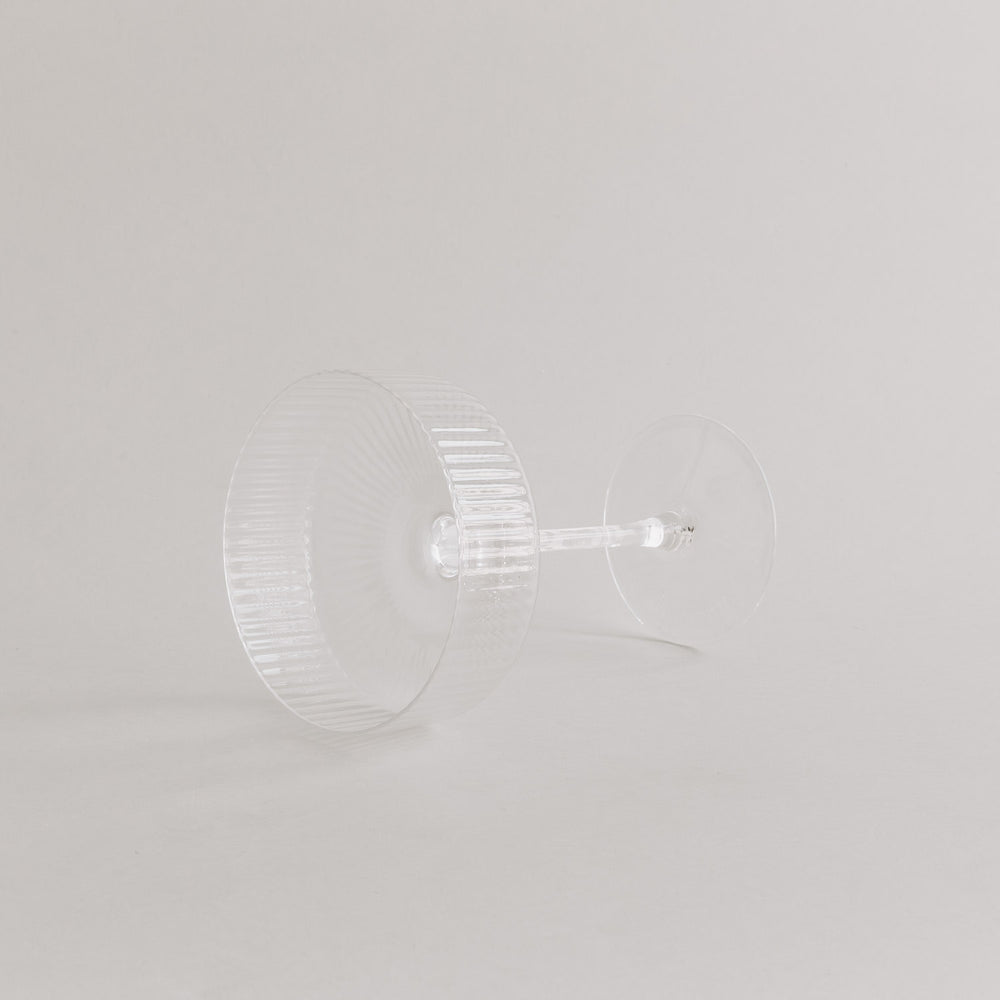 Produktaufnahme des leeren Champagnerglases in Seitenlage, edles Rillendesign sichtbar.