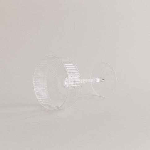 Produktaufnahme des leeren Champagnerglases in Seitenlage, edles Rillendesign sichtbar.