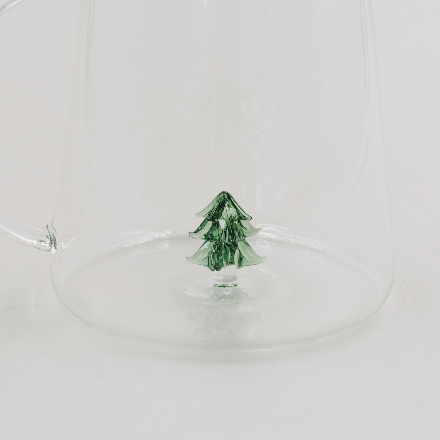 Detailaufnahme der grünen Tannenfigur im Boden der Karaffe – feine Handarbeit in hochwertigem Glas.