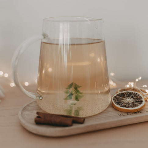 Karaffe mit gefülltem Getränk und Tannenfigur – perfekte Ergänzung für winterliche Genussmomente.
