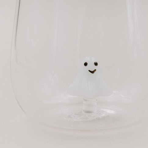 Nahaufnahme des Trinkglases mit schwebender 3D-Geistfigur aus Glas auf hellem Hintergrund