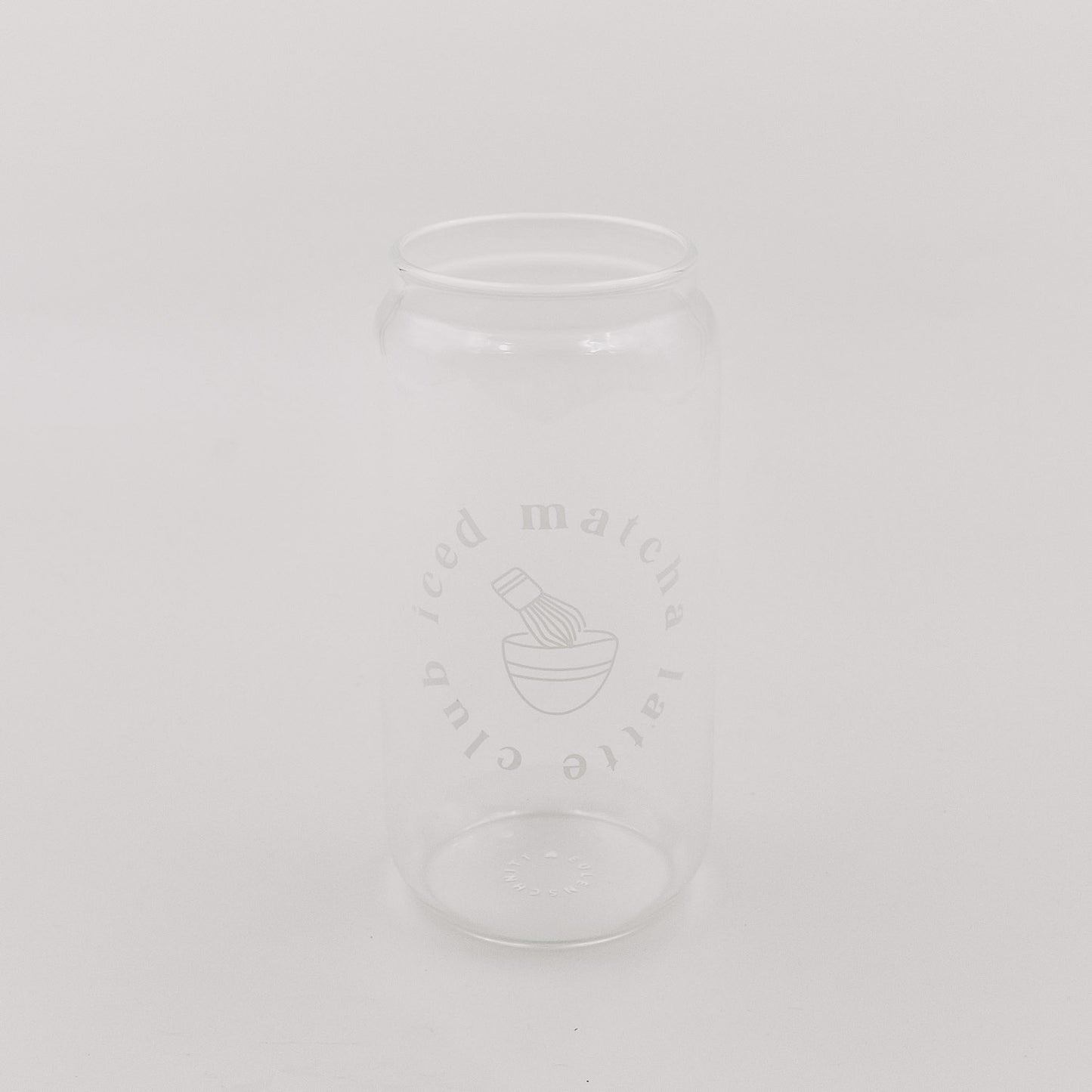 Leeres, transparentes Glas mit minimalistischem Matcha-Print. Das Glas steht vor einem schlichten, hellen Hintergrund.