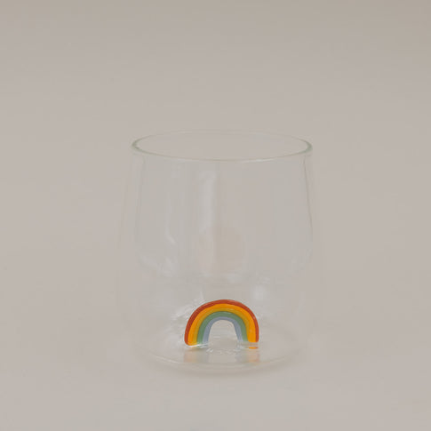 Klares Trinkglas mit buntem Regenbogen am Boden, schlichtes Design freigestellt