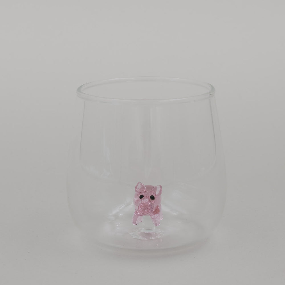 Freigestelltes Trinkglas mit Schwein Figur im Boden, minimalistisches Glasdesign
