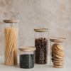 Vorratsgläser mit Holzdeckel gefüllt mit Spaghetti, Müsli und Keksen, Küchenorganisation