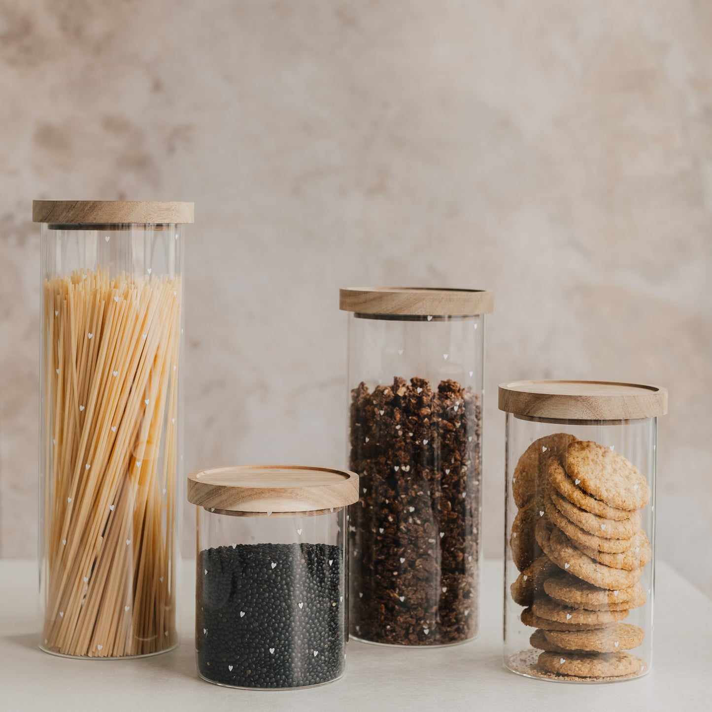 Vorratsgläser mit Holzdeckel gefüllt mit Spaghetti, Müsli und Keksen, Küchenorganisation