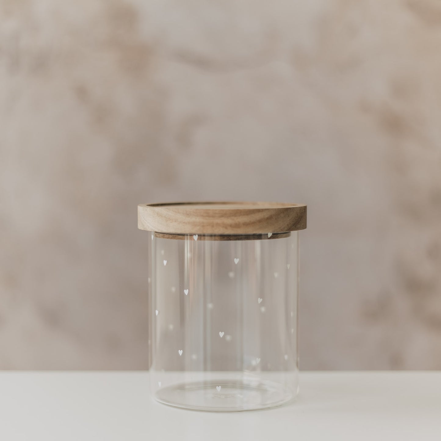 Transparentes Vorratsglas mit Holzdeckel und kleinen Herzdetails, dekorativ und schlicht