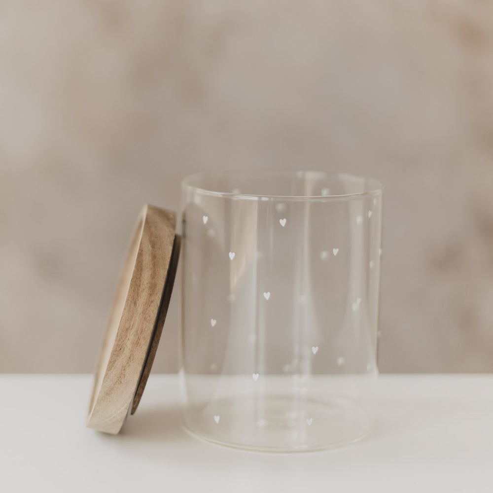 Offenes Glas mit Holzdeckel und weißen Herzmotiven, Detailansicht seitlich
