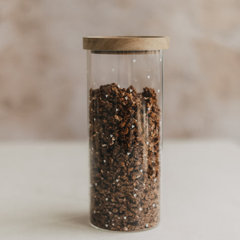 Hohes Vorratsglas aus Glas mit weißen Herzen, Holzdeckel und Schoko-Müsli