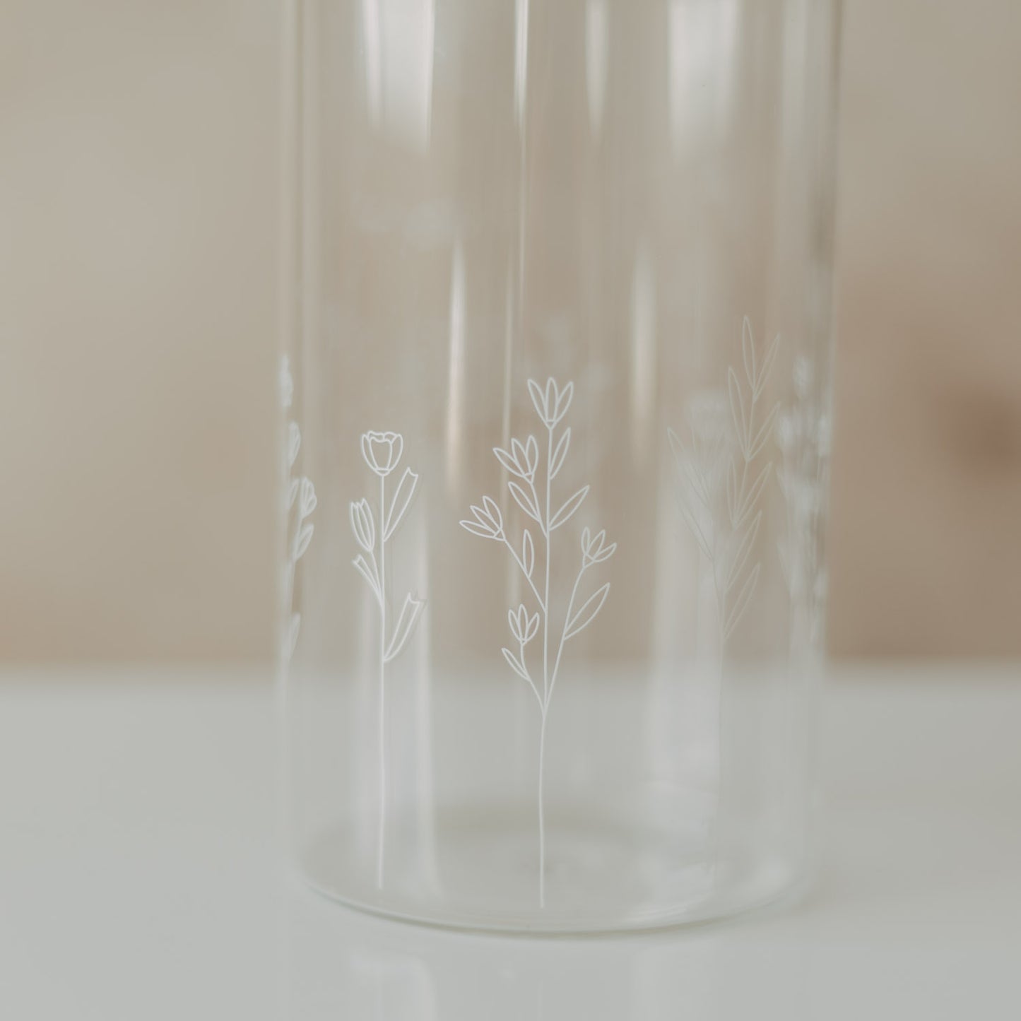 Nahaufnahme des filigranen weißen Wildblumen-Motivs auf einem transparenten Glas-Vorratsbehälter