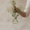 Glasvase mit schwarzen Herzen, mit locker arrangierten Blumen