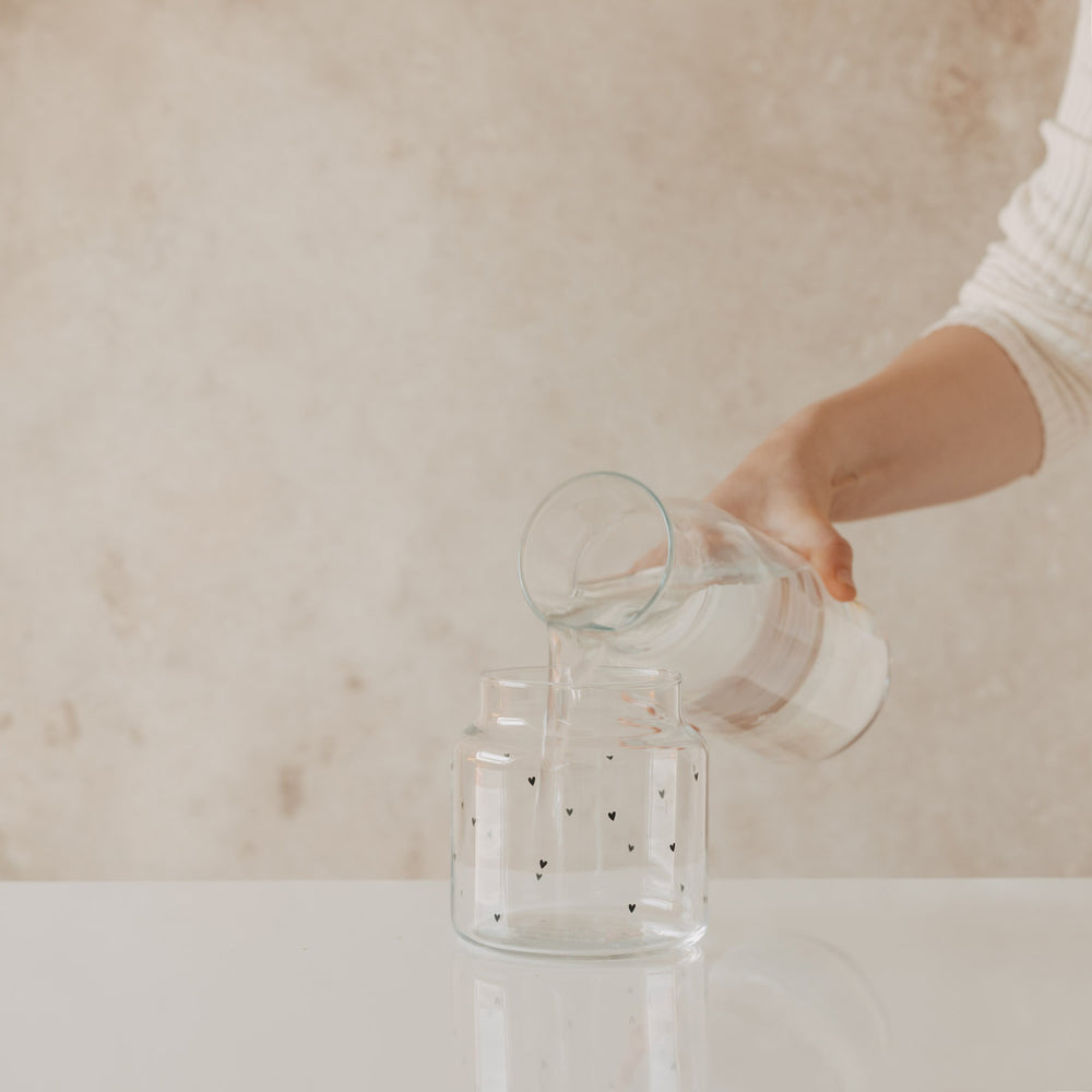 Glasvase mit Herzprint wird mit Wasser befüllt