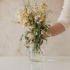 Glasvase mit Herzmuster mit frischem Blumenstrauß dekoriert