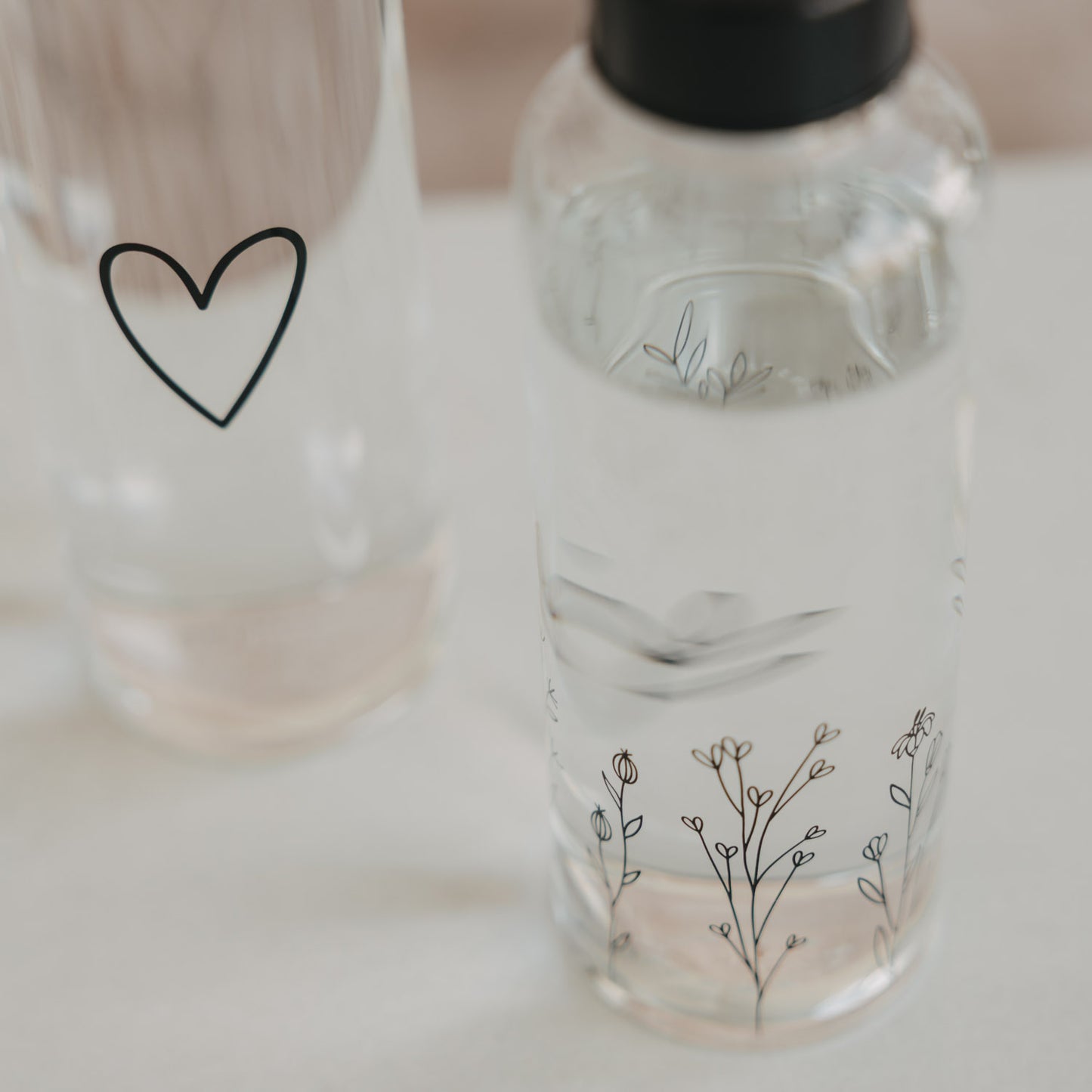 Detail Trinkflasche mit Blumenwiese Motiv und Herz, Glasflasche mit schwarzem Deckel