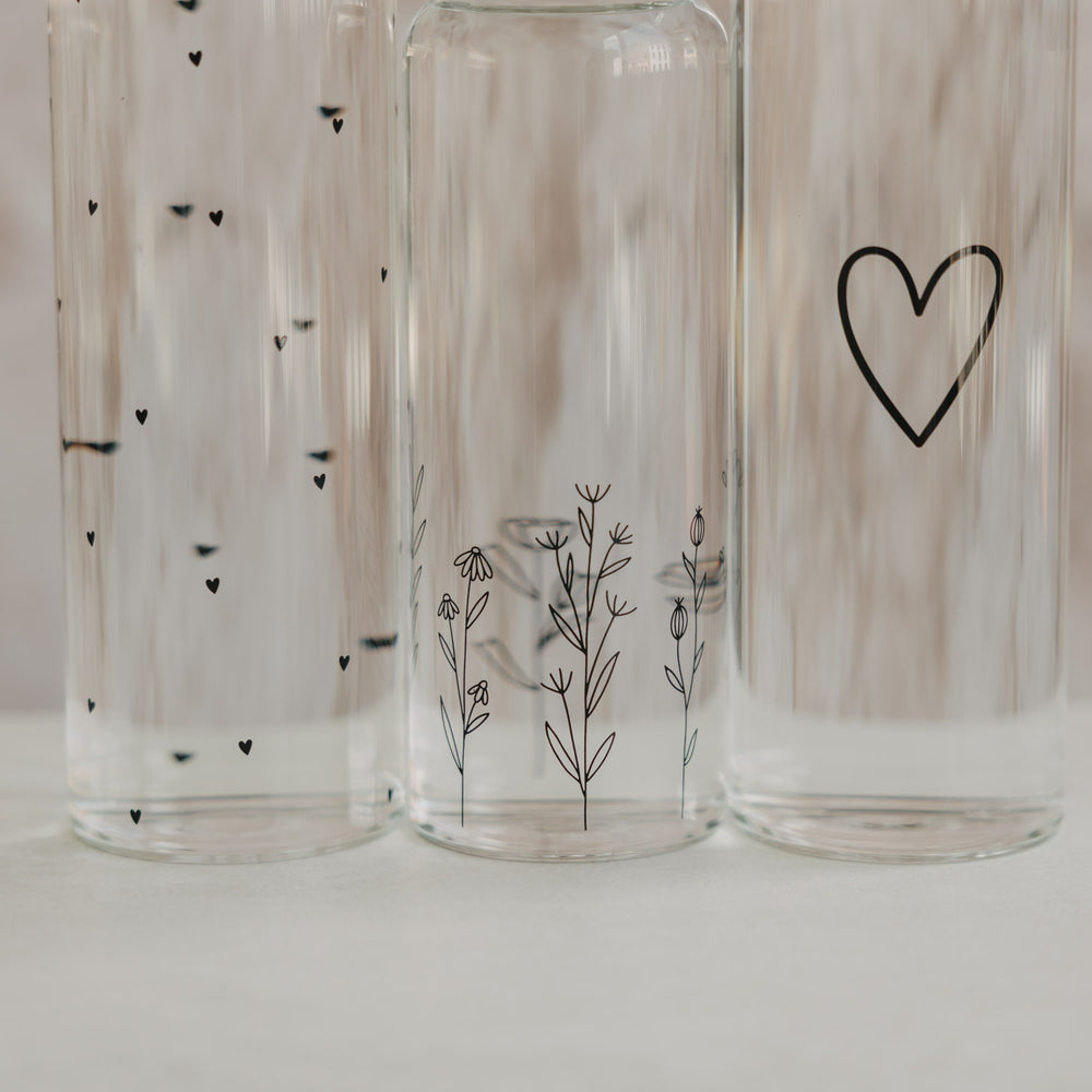 Detail Glasflaschen mit feinen Herz- und Blumenillustrationen im transparenten Design