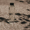Glas Trinkflasche mit Herzmuster draußen im Sonnenlicht, schlicht und modern