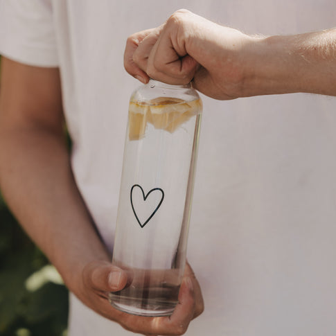 Trinkflasche Herz 750 ml in der Hand mit Zitronenwasser, ideal für unterwegs