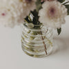 Nahaufnahme der geriffelten Bubble Vase aus Glas mit Blumenstrauß und sichtbaren Blumenstielen im Wasser.