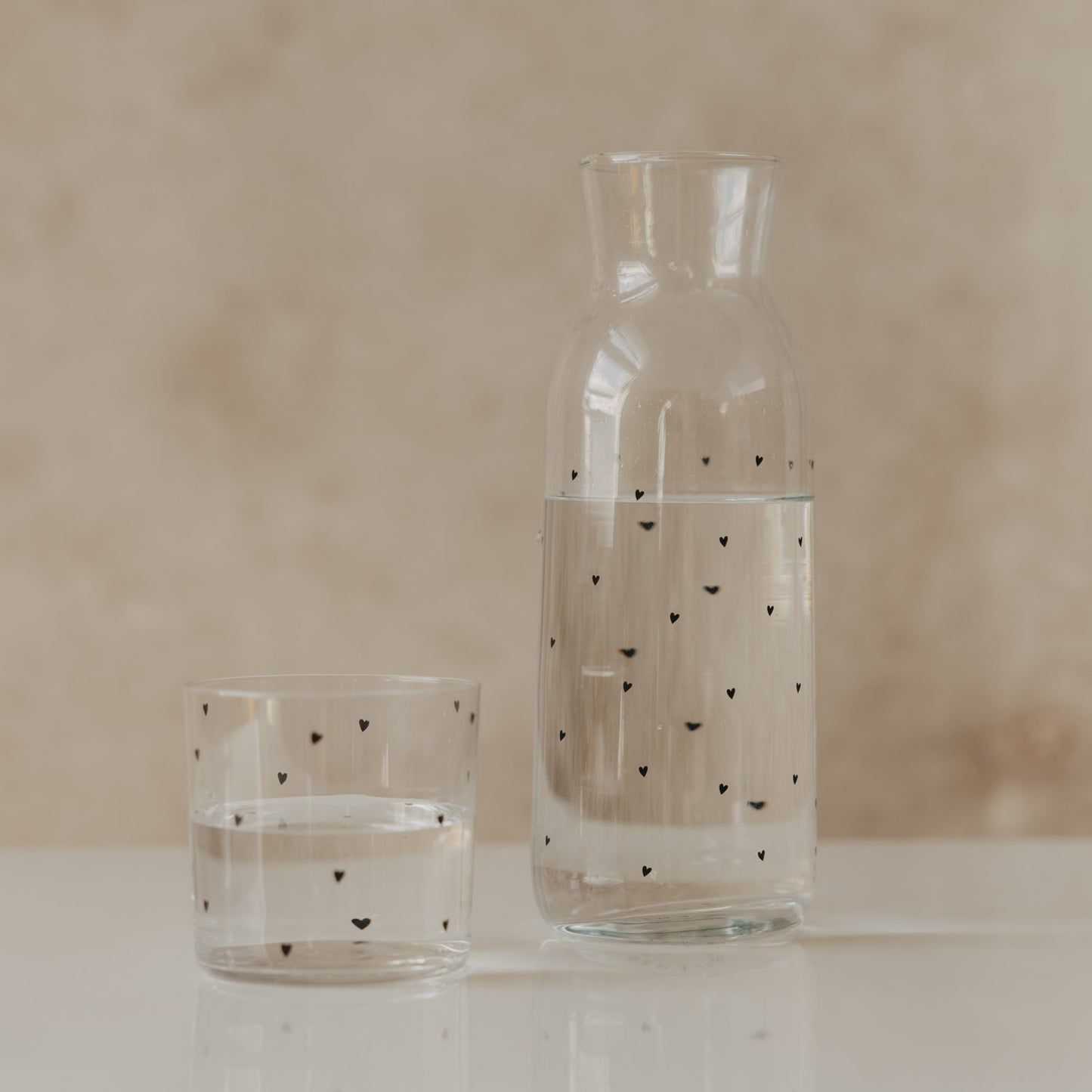 glas.jpg
Glaskaraffe und Trinkglas mit kleinen schwarzen Herzen, gefüllt mit Wasser