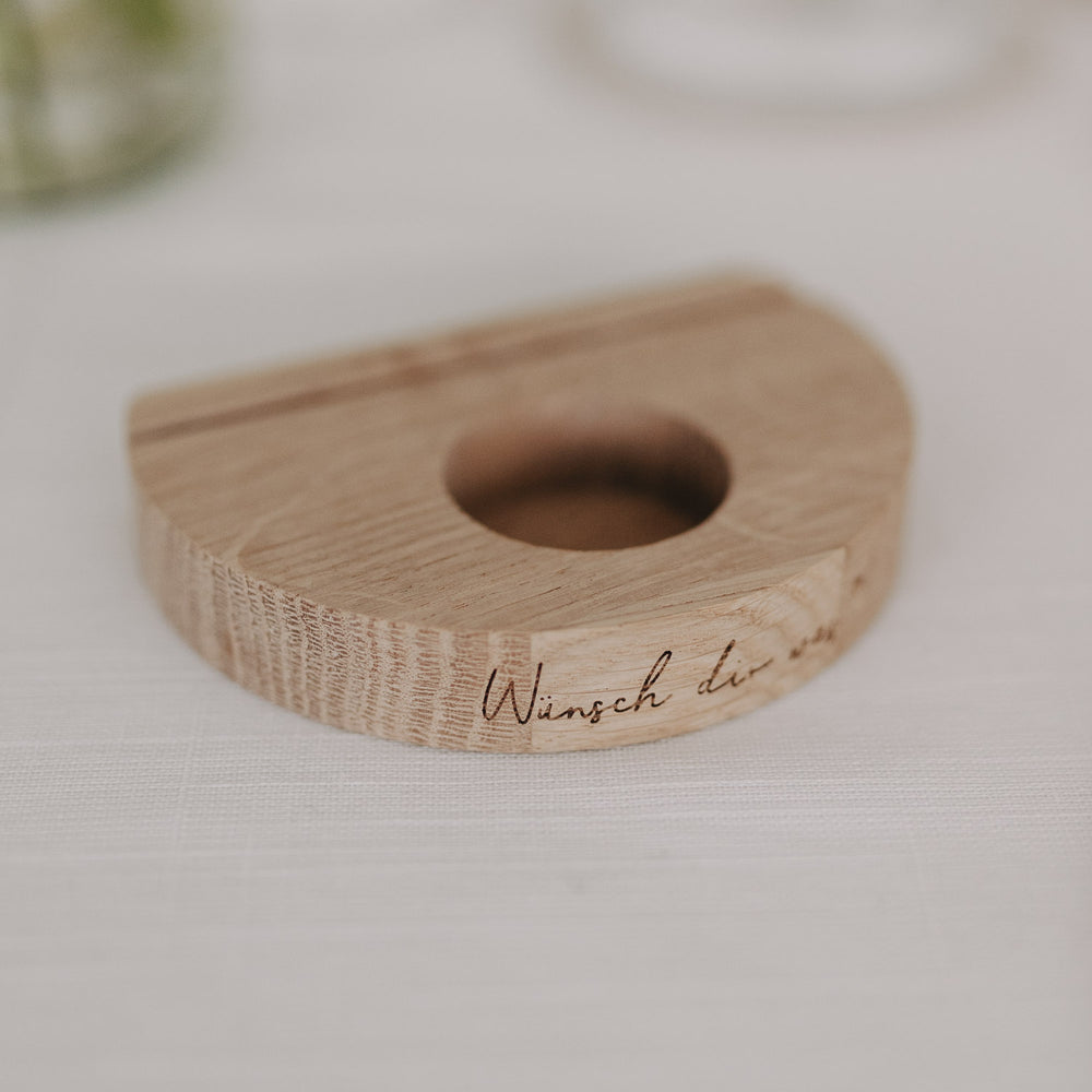 Holz-Kartenhalter „Wünsch dir was“ mit Teelicht-Aussparung und Gravur auf heller Tischdeko.