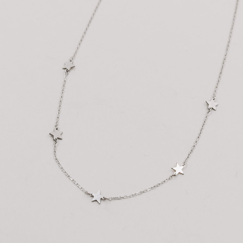 Silberne Kette mit kleinen, glänzenden Sternanhängern auf weißem Hintergrund.